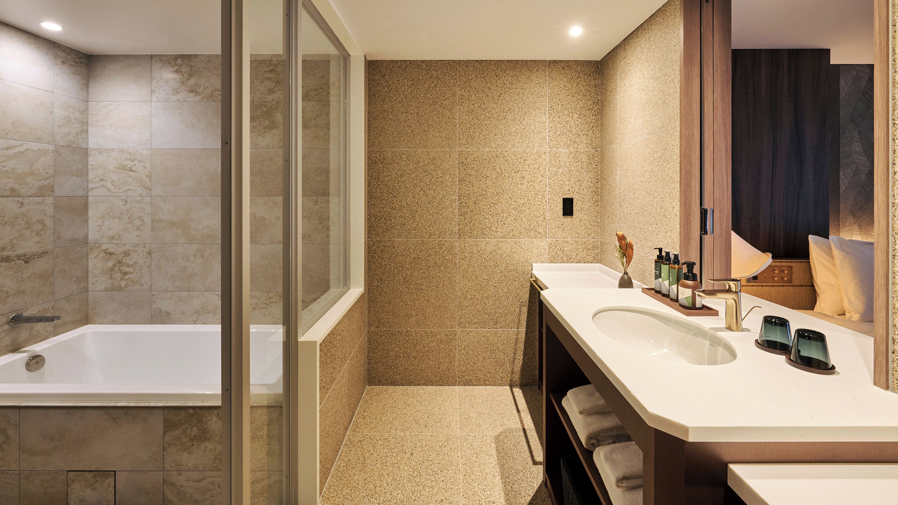 Une salle de bain moderne équipée d’une baignoire, d’une zone de douche et d’un meuble-lavabo avec un évier et un miroir.