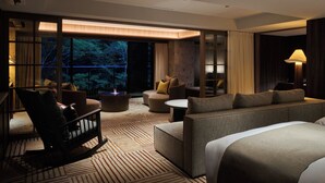 A modern hotel room with a large bed, a sofa, a chair, and a small table. There is a large window with a view of trees outside. - GLAMDAYSTYLE HOTEL&RESORT KYU-KARUIZAWA (Karuizawa)