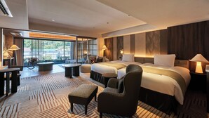 A hotel room with a large bed, two bedside tables, a sofa, a chair, a small table, and a large window with a view of the outdoors. - GLAMDAYSTYLE HOTEL&RESORT KYU-KARUIZAWA (Karuizawa)