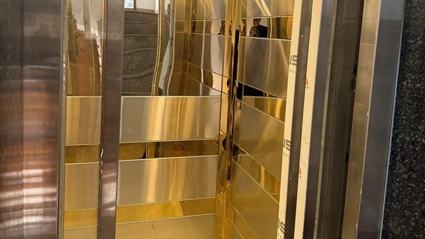 Un ascensor con paredes metálicas y superficies reflectantes.