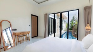 A bedroom with a large bed, a wooden desk, a mirror, and a view of a swimming pool. - Villa Sardegna Ubud (Ubud)