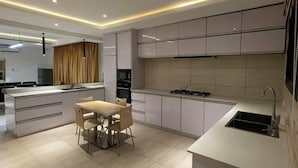 Una cocina moderna con una isla central, comedor y horno empotrado.