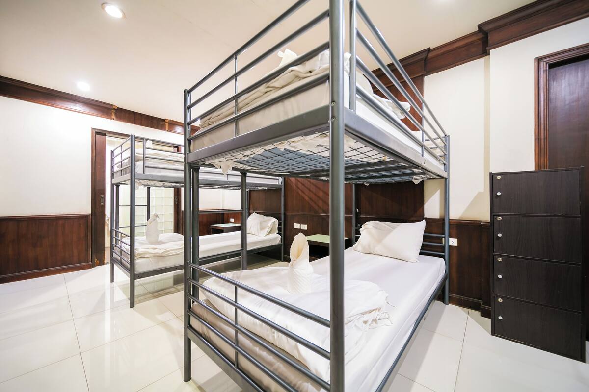 A bunk bed room with a wooden wardrobe and a door.