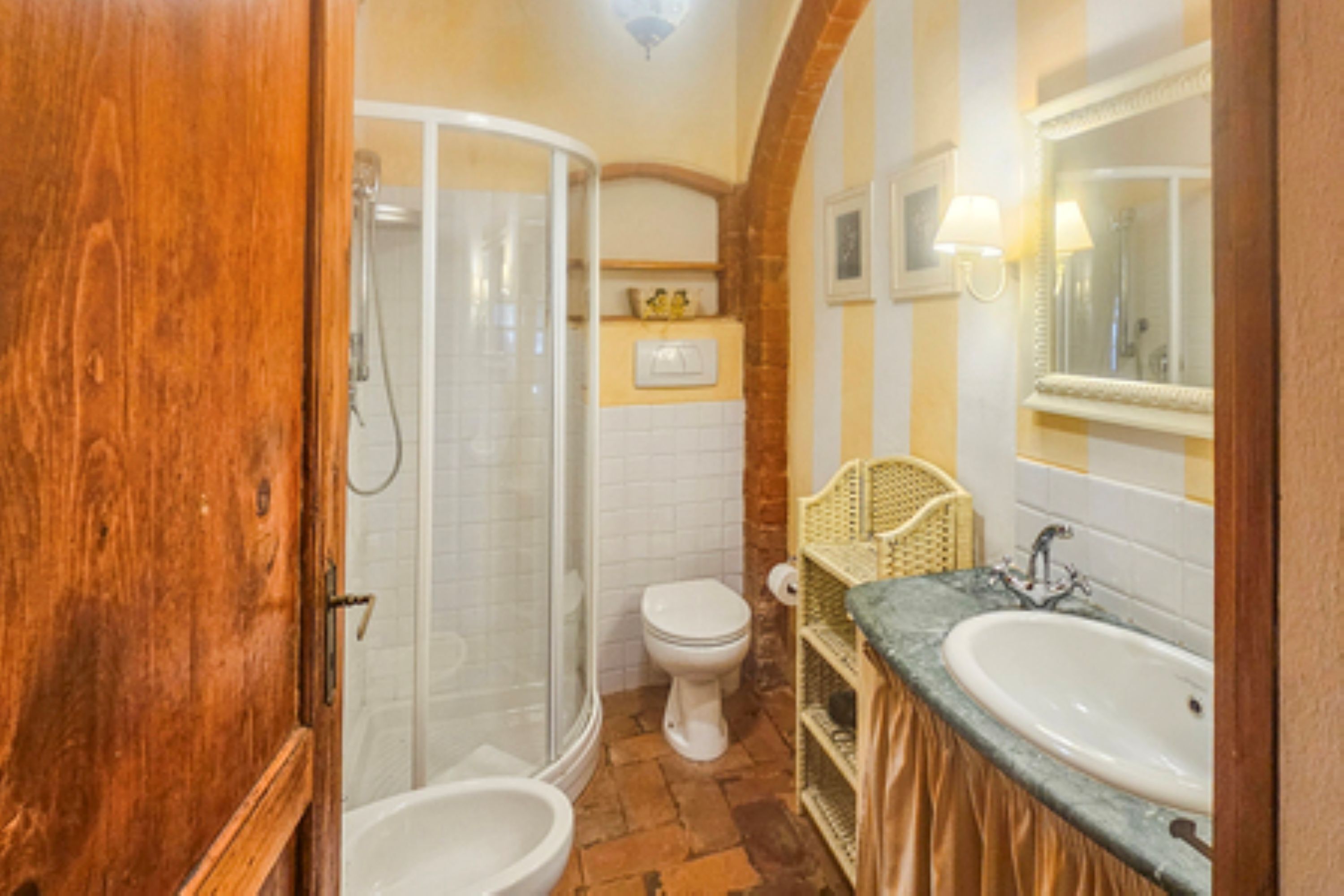 A bathroom with a shower, toilet, and two sinks.