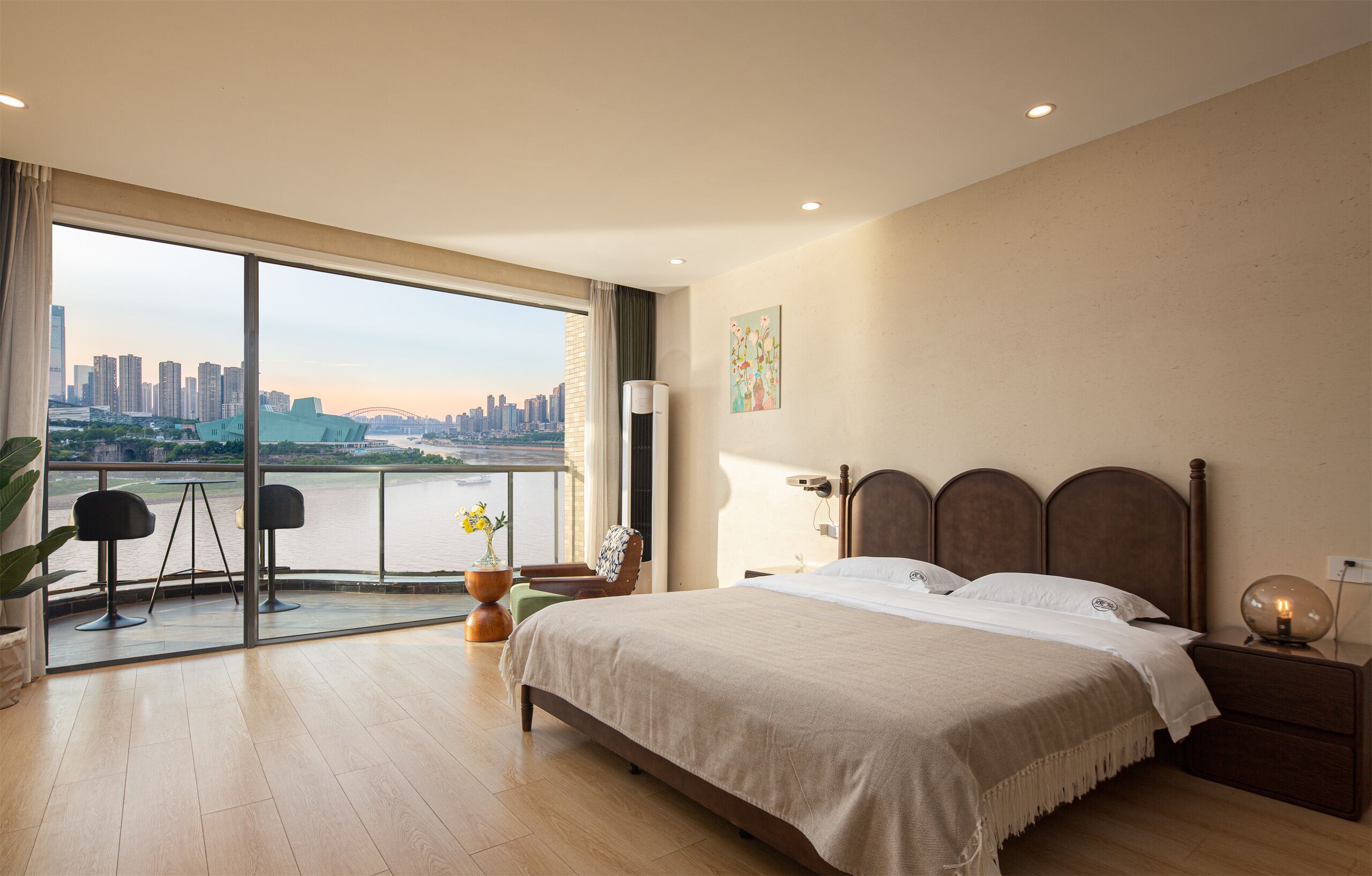 Una camera da letto con una grande finestra, un letto, un comodino e una sedia.