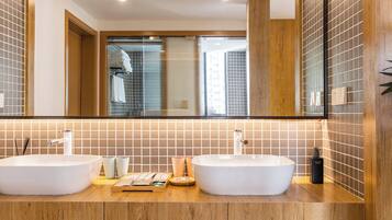 A bathroom with two large white sinks, a wooden countertop, and a mirror above.
