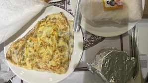 A tray with two plates of food, a banana, a packet of Amul butter, and a foil-wrapped item. - Hotel Aston  (Kolkata)