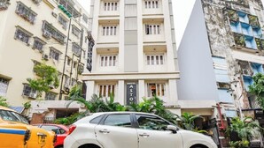 A multi-story hotel with balconies, a red roof, and a sign reading "HOTEL ASTON." - Hotel Aston  (Kolkata)