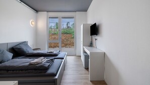 A modern bedroom with two beds, a desk, and a TV. - Room '8' with Shared Terrace and Wi-Fi (Dußlingen)