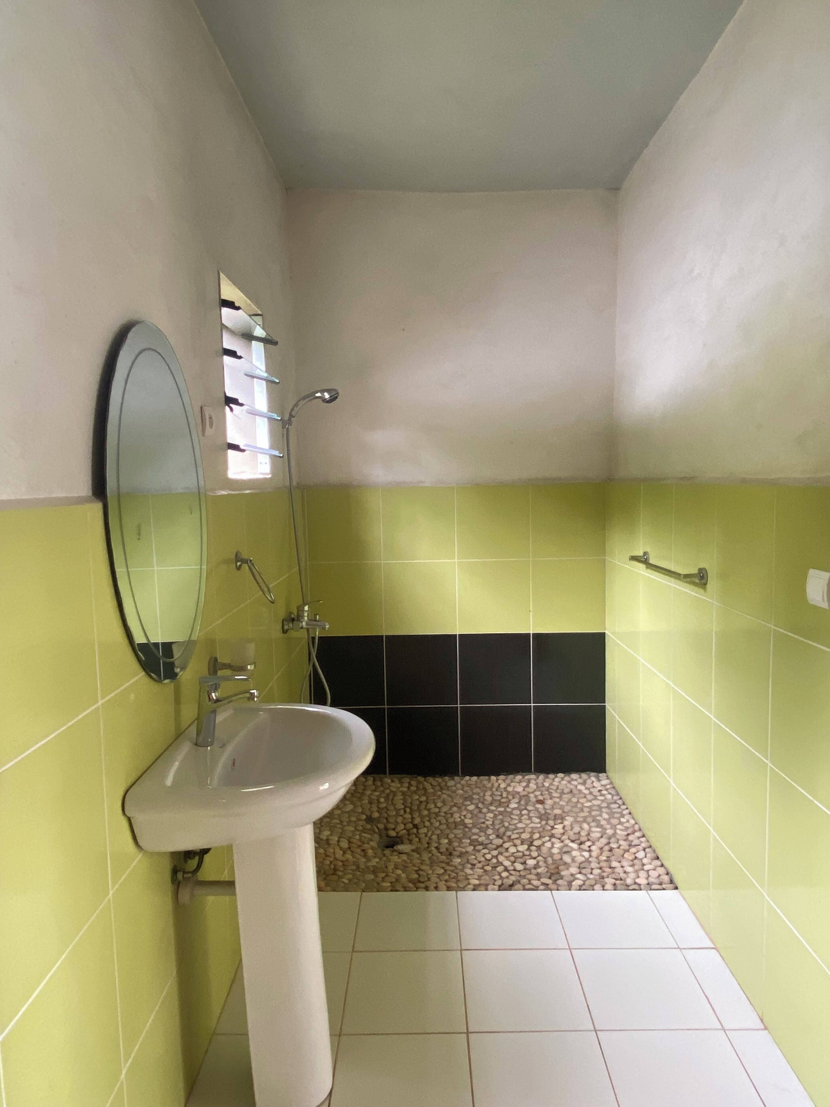 A bathroom with a sink, mirror, and shower.