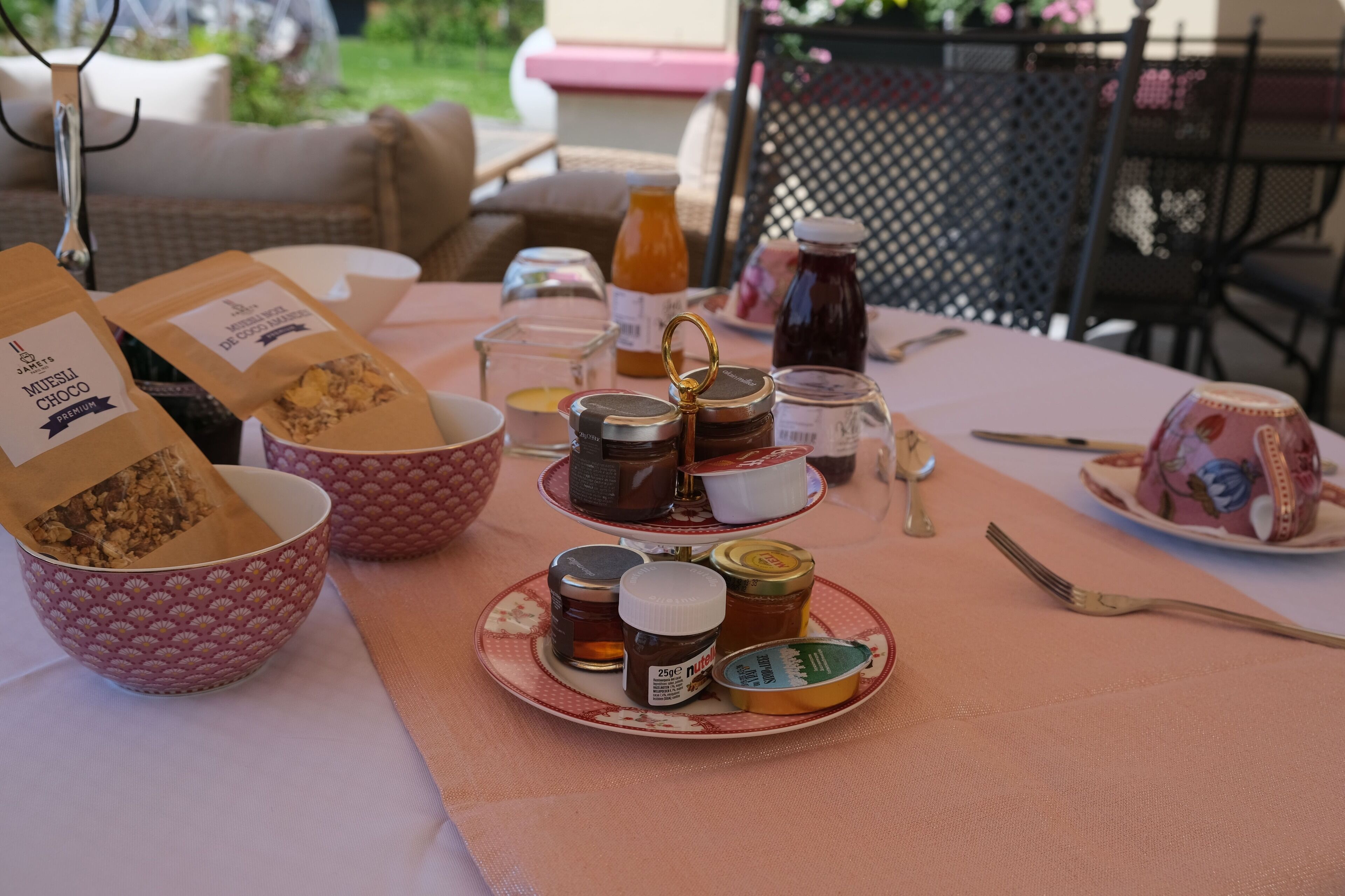 Egy asztal, melyen különféle ételek vannak, többek között mézes üvegek és csokoládé, valamint egy tányér, rajta egy csészével.