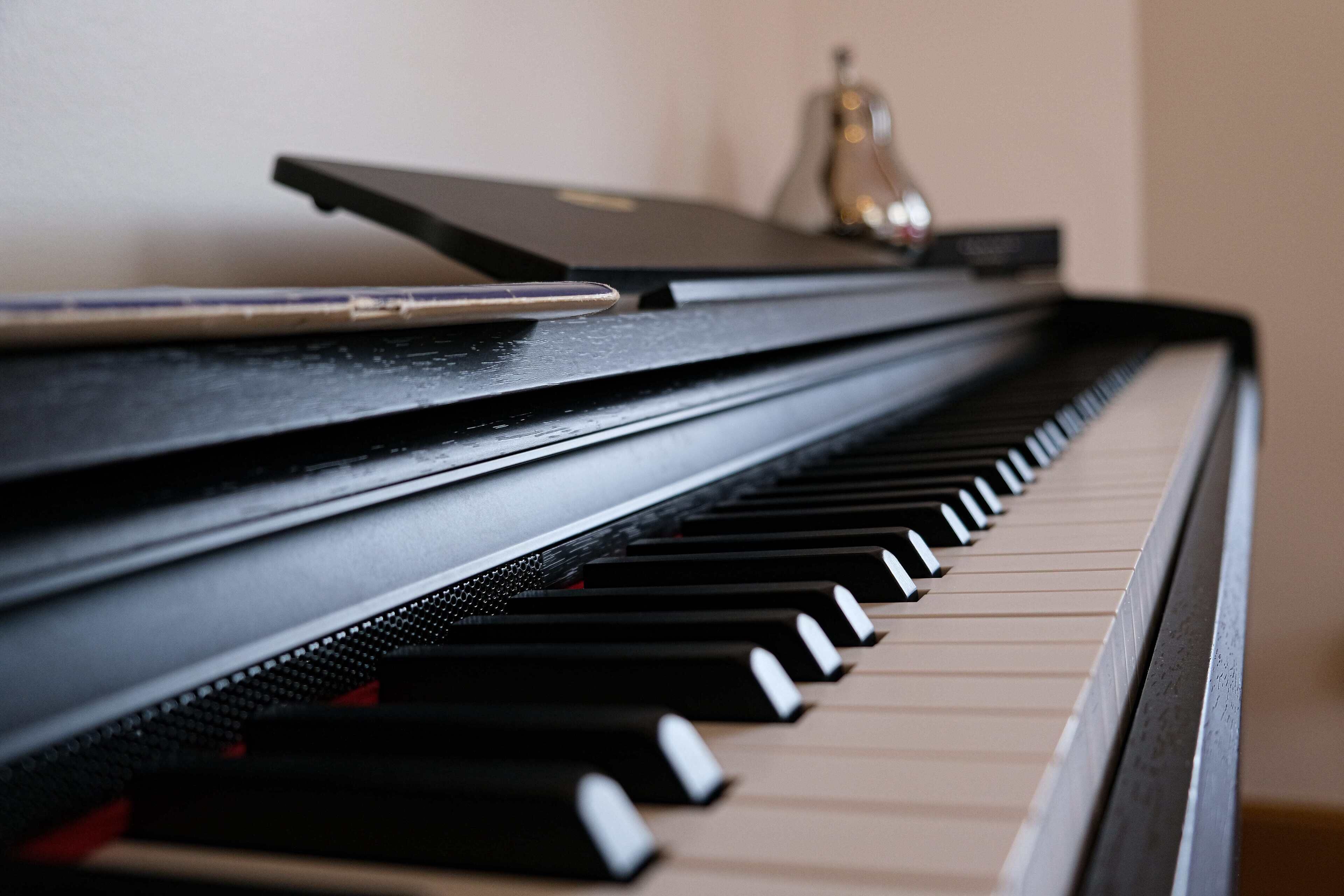 A close-up of a piano keyboard with a bell inside the piano.
