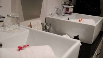 Un bagno con due lavandini, uno specchio e un dispenser di sapone.