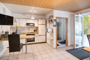 Eine moderne Küche mit Essbereich, Fernseher und Kühlschrank.