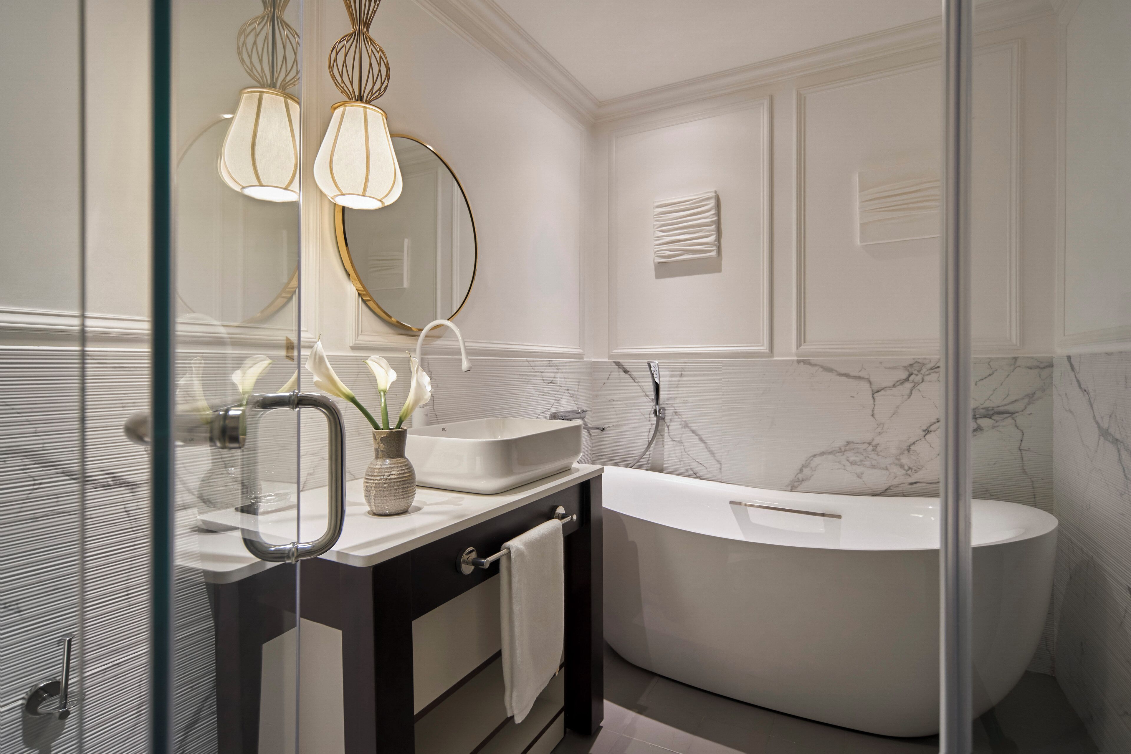 A modern bathroom with a freestanding bathtub, a vanity with a mirror, and a glass shower enclosure.