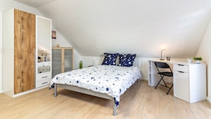 Une chambre à coucher avec un lit, un bureau et une armoire.