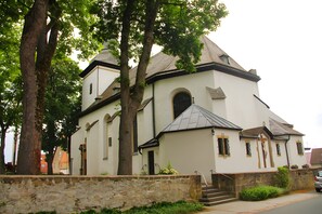 Eine Kirche mit einer Steinmauer, einem Glockenturm und einer Treppe zum Eingang.