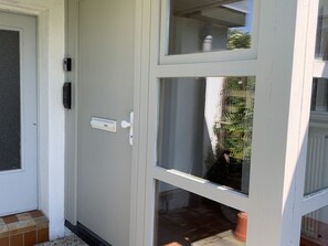 Una puerta blanca con un buzón y una ventana.