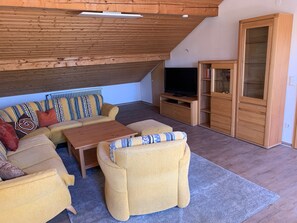 A cozy living room with a sofa, armchairs, a coffee table, a TV, and a wooden cabinet. - Apartment 'Käppeler' with Balcony and Wi-Fi (Salem)