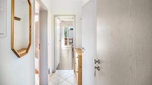 A hallway with a wooden door, a mirror, and a view into another room. - Apartment '02' with Shared Terrace, Balcony and Wi-Fi (Lindau)