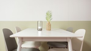 A minimalist dining table with a white surface and four chairs.