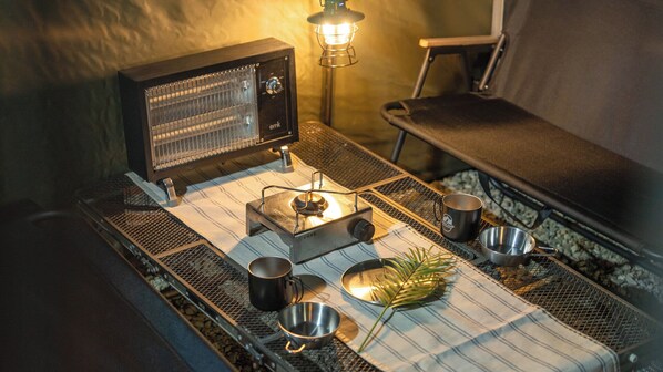 Un equipo de cocina portátil con estufa, ollas y una linterna.