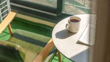 Una mesa con una taza blanca de café y un libro abierto, que invita a la lectura.