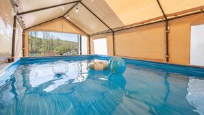 An indoor swimming pool with clear water, a glass ball, and a floating ring. - Daebudo Freesia Private Pool Villa (Ansan)