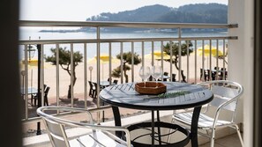 A balcony with a table, chairs, and a view of the beach and water. - The Seaside 2, Taean (Taean)