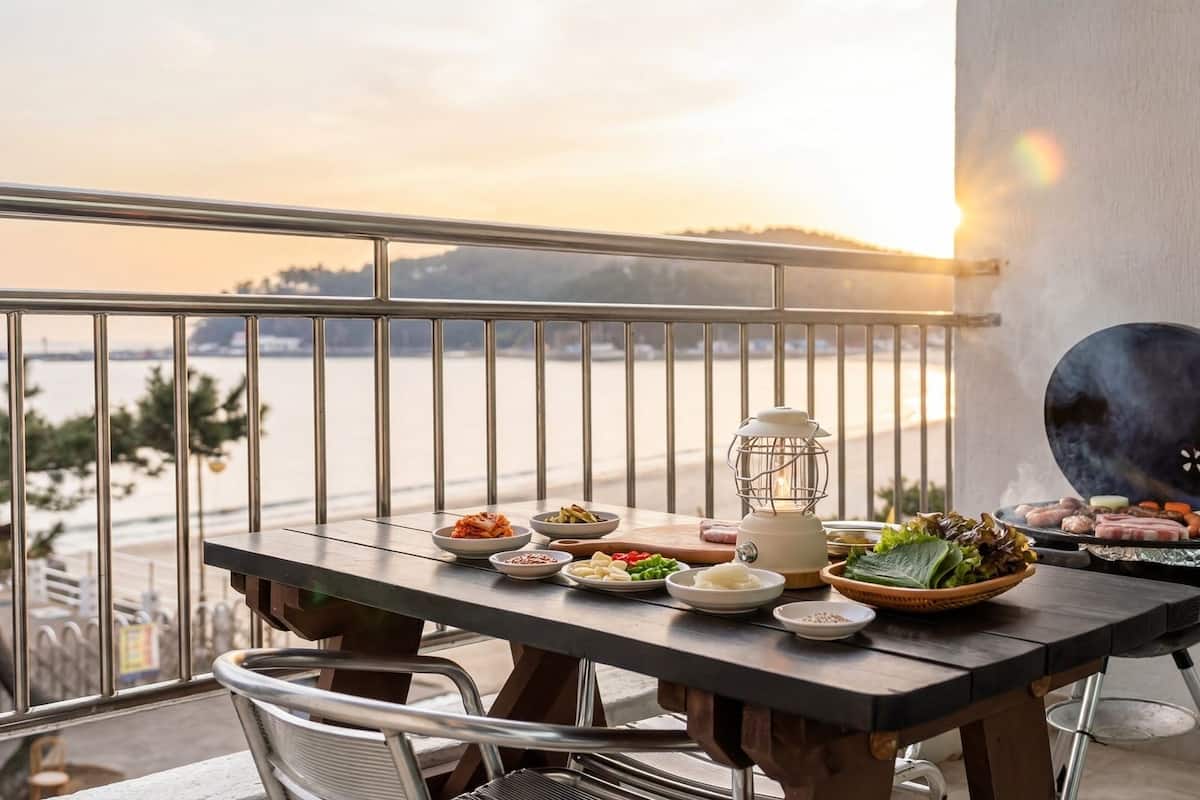 A balcony with a table set for a meal, overlooking a body of water.