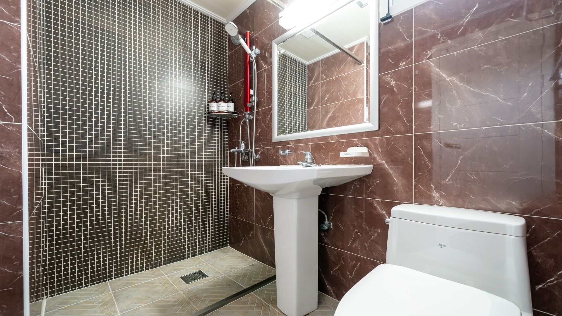 A bathroom with a shower, a sink, and a toilet.