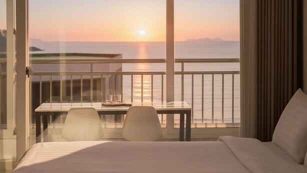 A hotel room with a balcony overlooking the sea at sunset. - The Seaside 2, Taean (Taean)