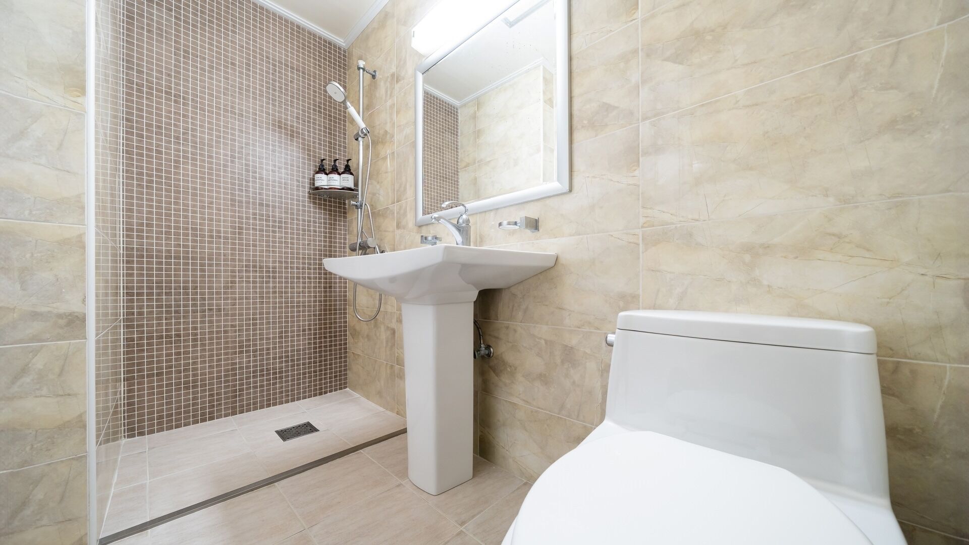 Ein Badezimmer mit Dusche, Waschbecken und Toilette.
