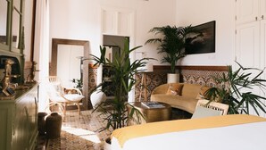 A room with a bed, a sofa, a dining area with chairs, and a large potted plant. - Dreamsea Gran Canaria Boutique (Moya)