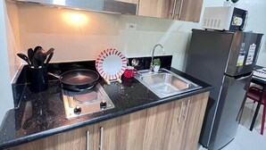 Una cucina moderna con mobili in legno, un frigorifero in acciaio inossidabile e un piano cottura a gas.