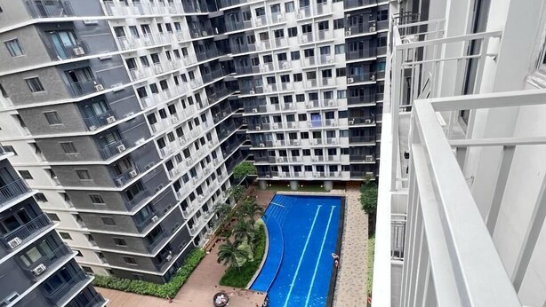 Un edificio residenziale a grattacielo con piscina e area salotto all'aperto.