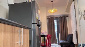 Una cucina moderna con frigorifero, mobili in legno e un'area pranzo con tavolo e sedie.