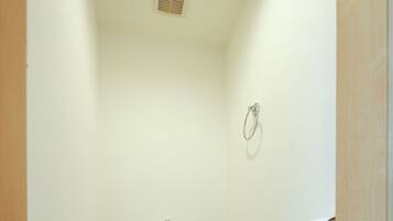 A small, narrow bathroom with a white toilet, a wooden floor, and a white wall.