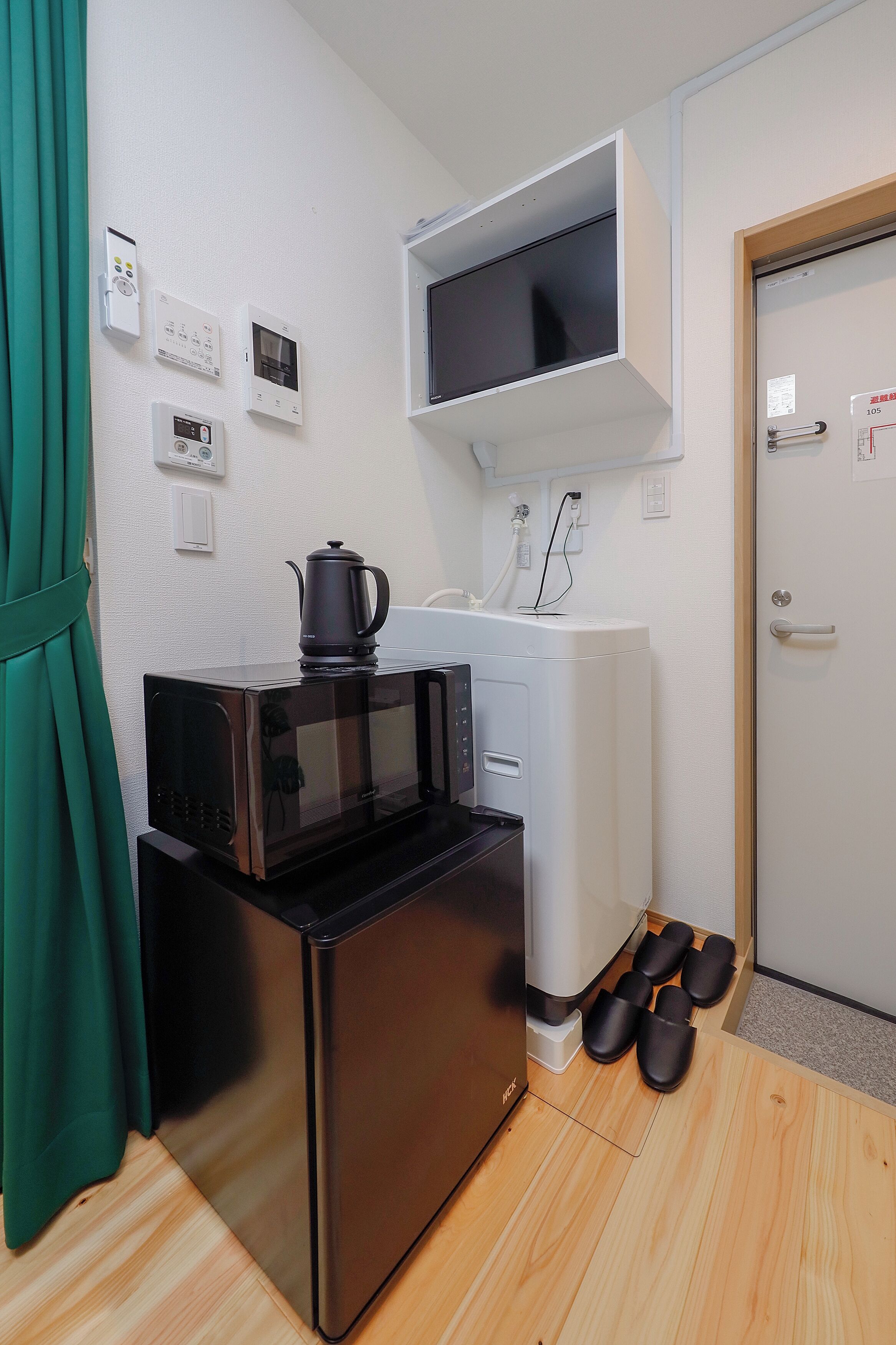 A compact kitchenette with a microwave, coffee maker, and a small refrigerator.