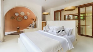 Une chambre spacieuse avec un grand lit, une table de chevet en bois et un mur décoratif orné de divers objets.