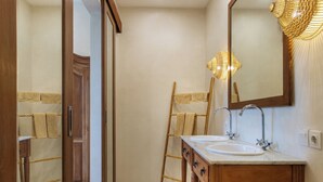 Une salle de bain avec un meuble-lavabo en bois, deux vasques, un miroir et un porte-serviettes.