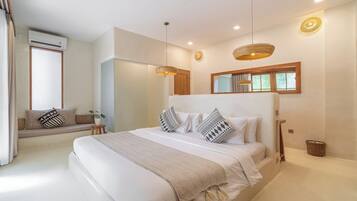 Un dormitorio moderno con una cama grande, un banco empotrado y un ventanal amplio.
