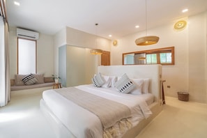A modern bedroom with a large bed, a built-in bench, and a large window. - White Goose Boutique Hotel (Tibubeneng)