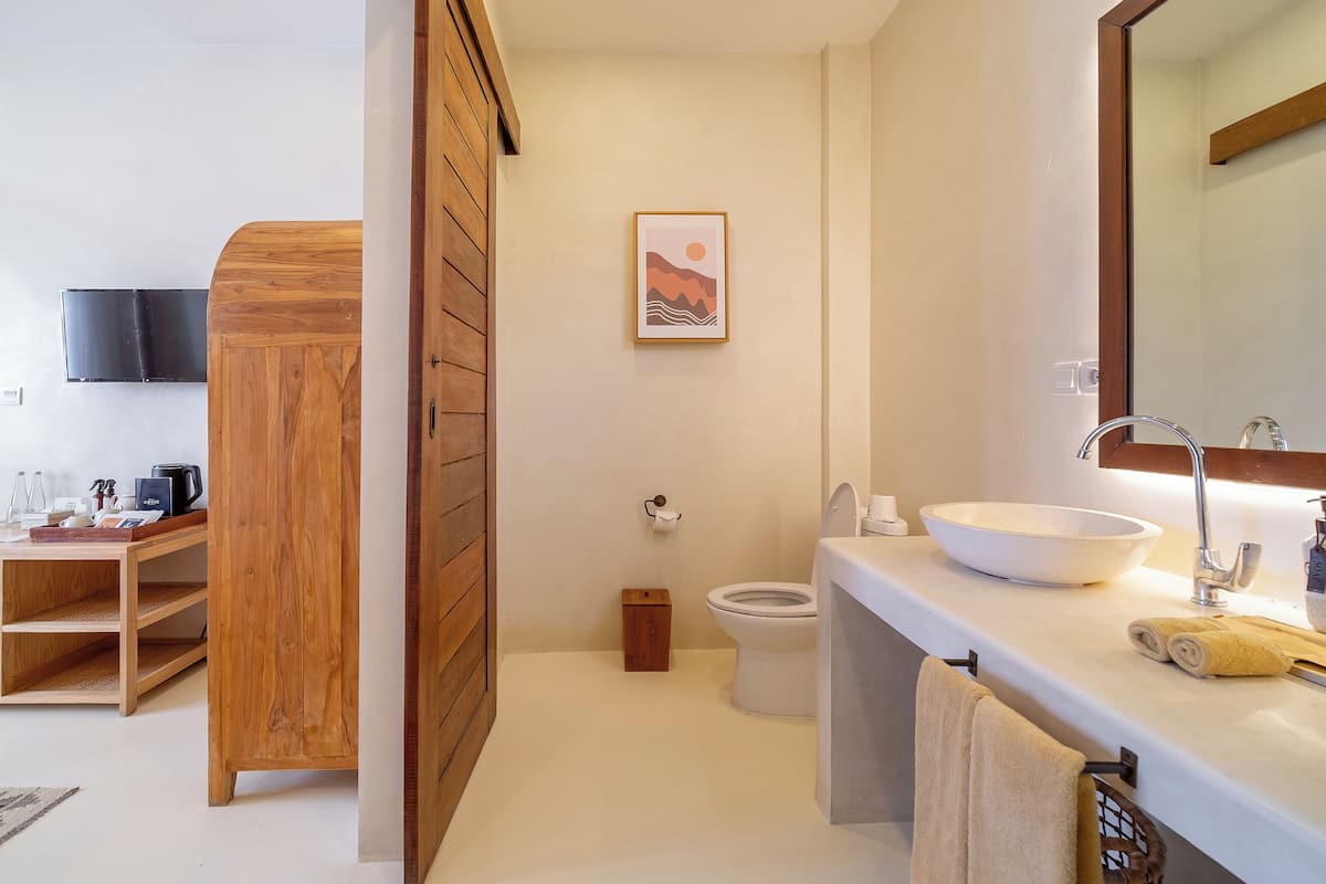 Studio, terras | Badkamer | Een bad/douchecombinatie, een regendouche, gratis toiletartikelen