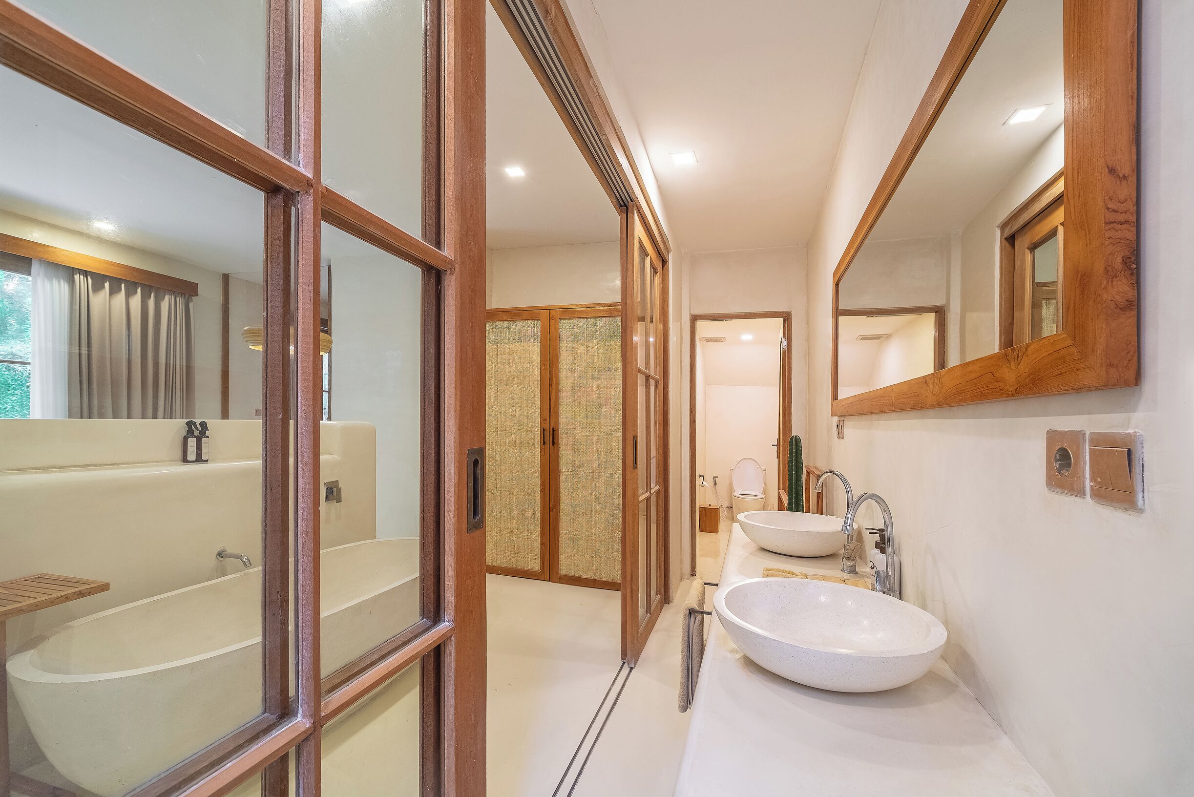A modern bathroom with a freestanding bathtub, a large mirror, and a sink with a vessel basin.