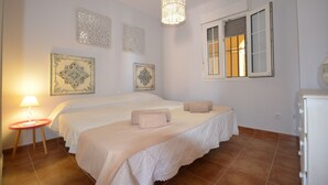 A bedroom with a bed, a bedside table, a lamp, and decorative wall art.