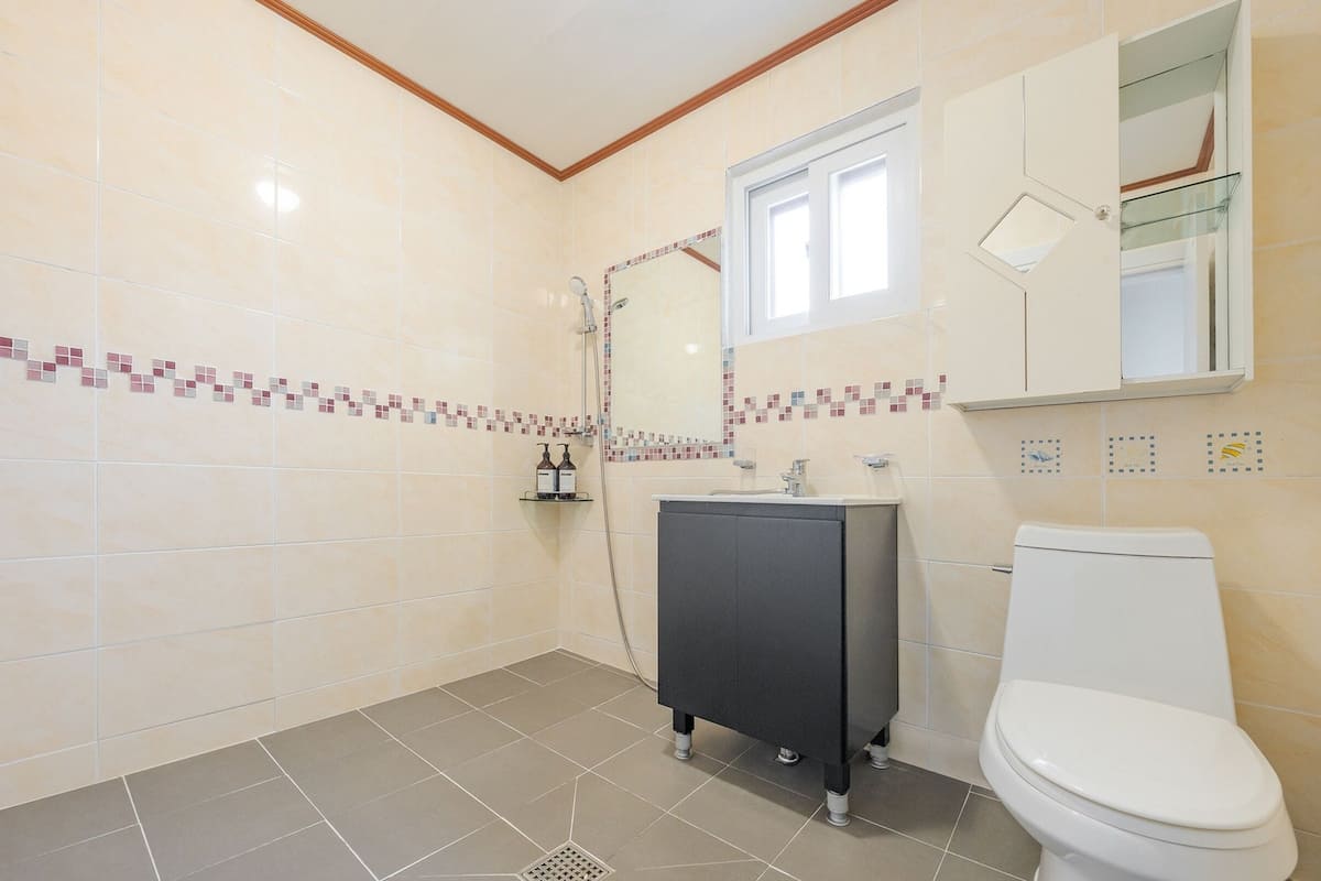 A bathroom with a toilet, a sink, and a shower.