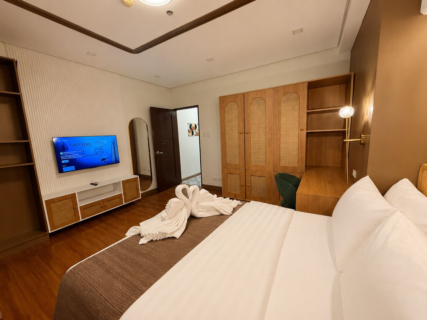 Ein Hotelzimmer mit Bett, Fernseher, Kleiderschrank und Spiegel.