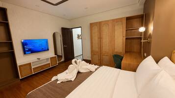 Ein Hotelzimmer mit Bett, Fernseher, Kleiderschrank und Spiegel.