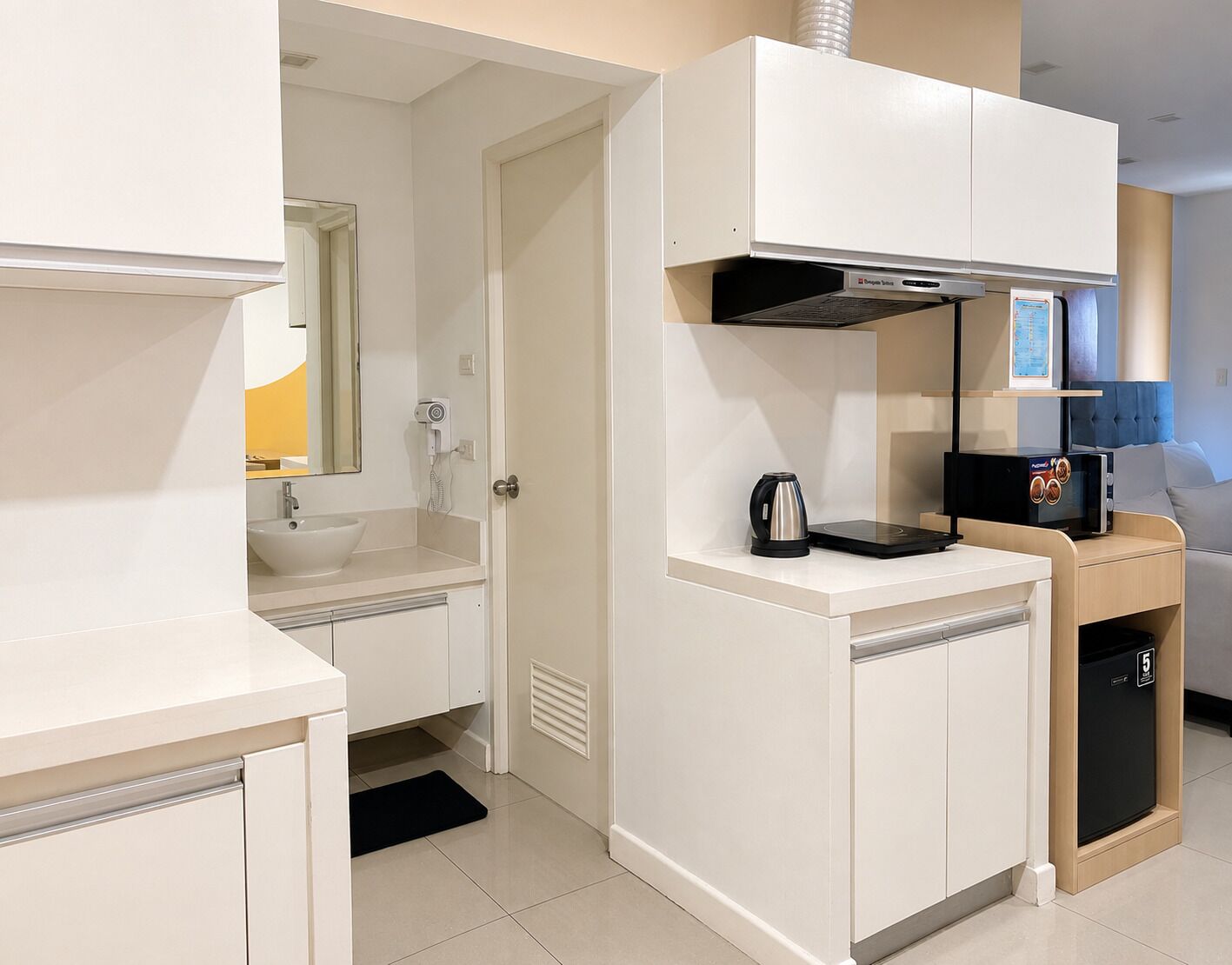 A modern kitchen with a built-in microwave, kettle, and coffee machine.